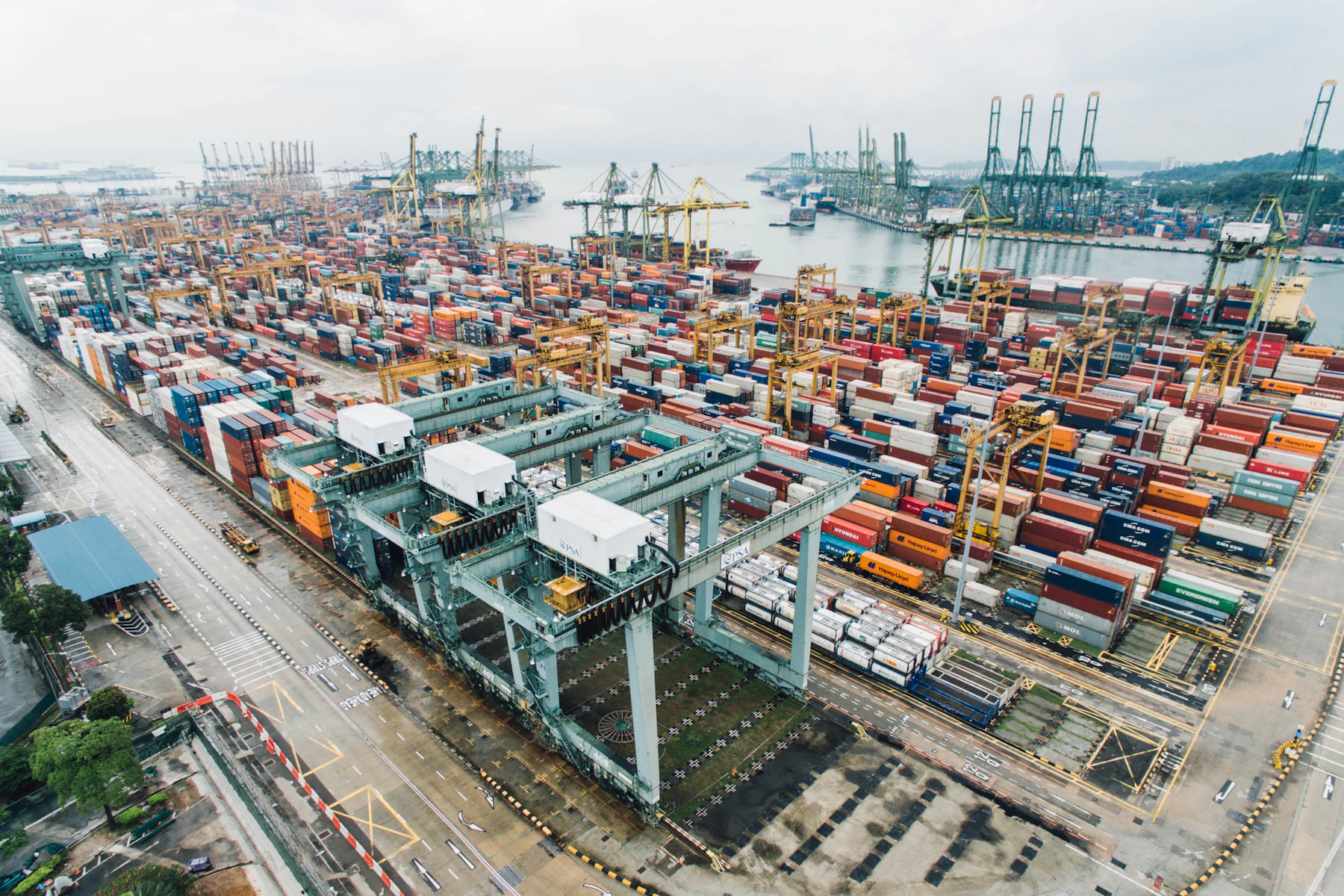 Container cranes and stacked containers at a cargo terminal.