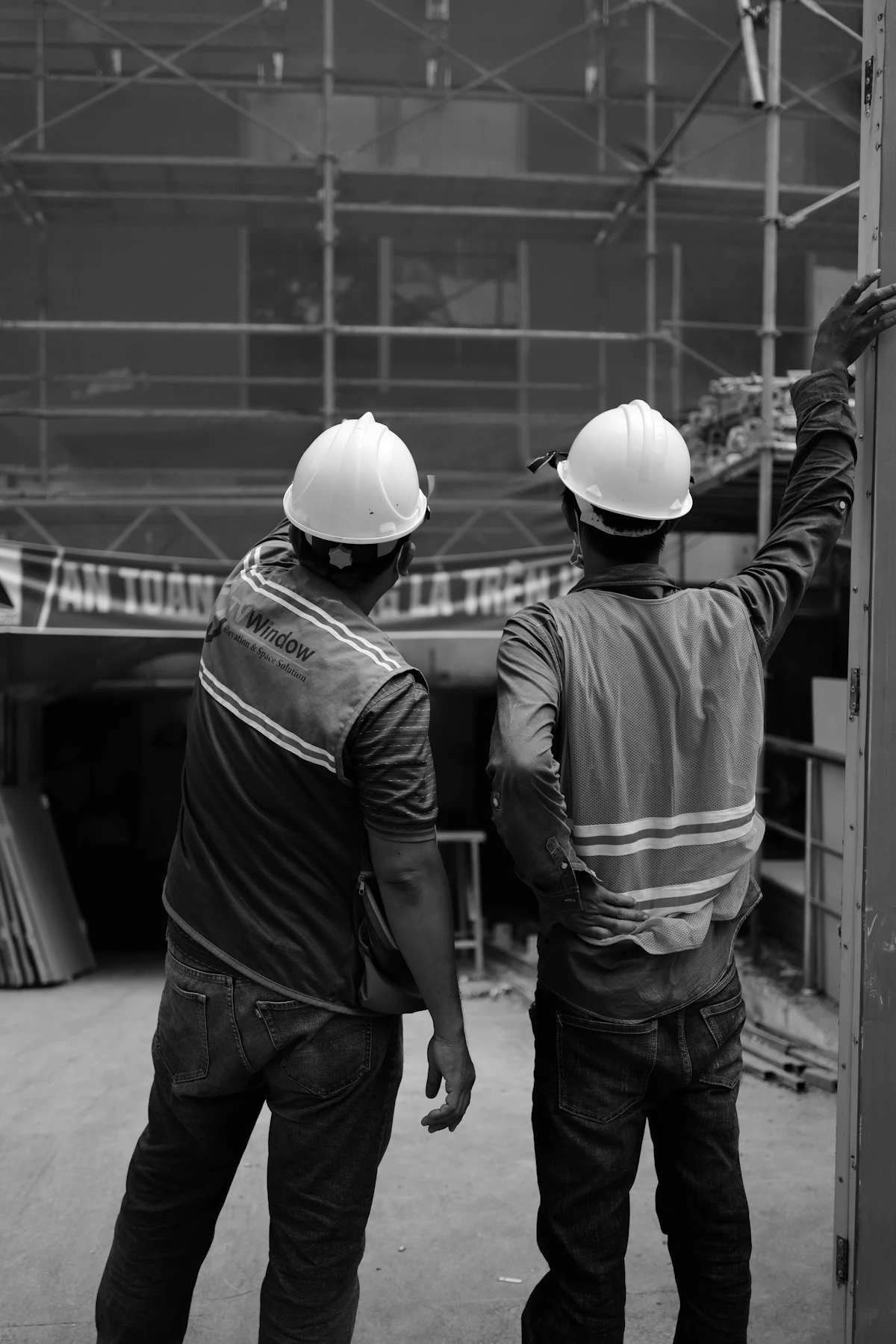 Two workers in safety helmets at a construction site.
